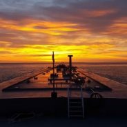 barge headed out at sunset on the water