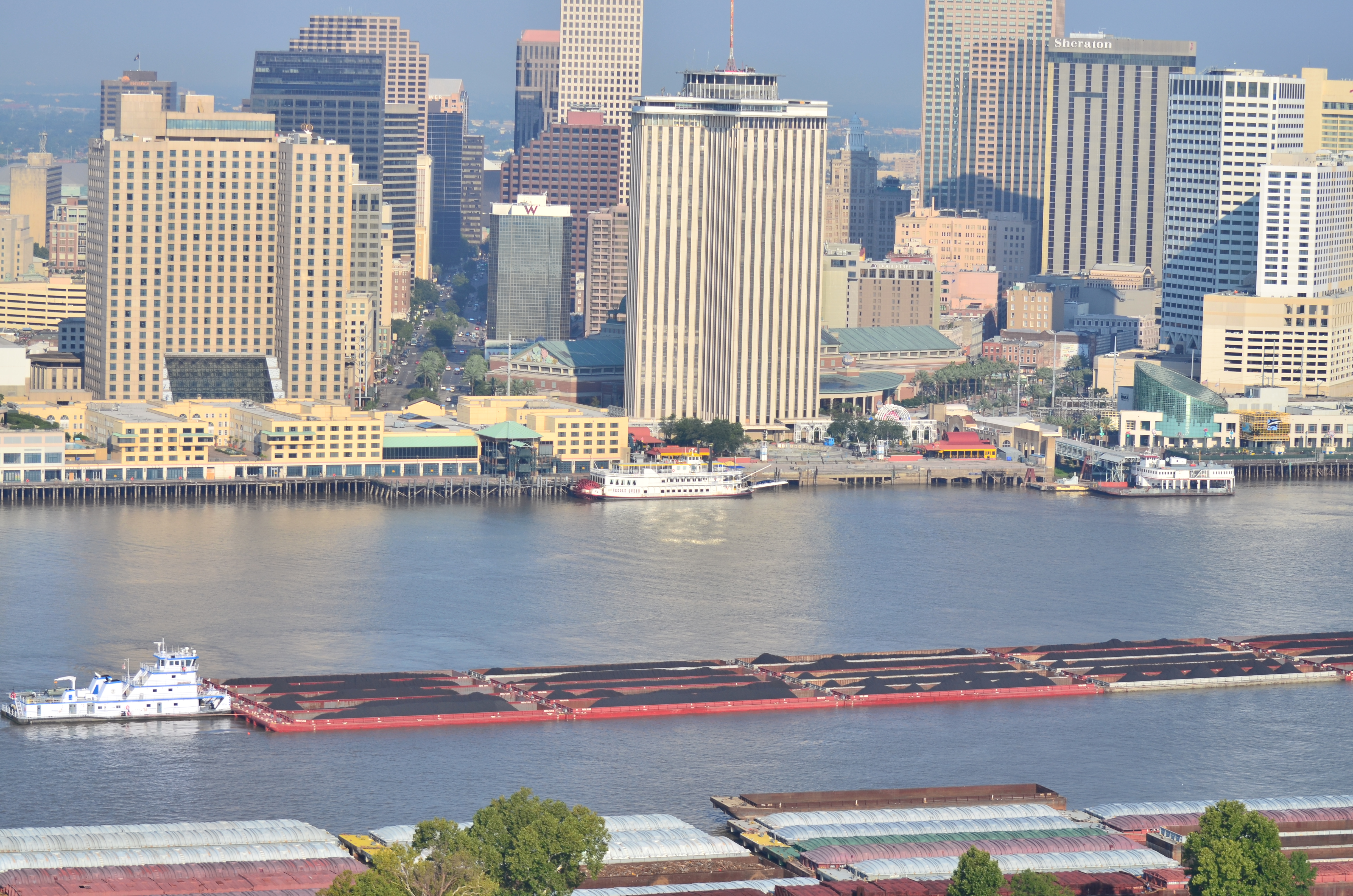 Towboat transporting dry cargo with city in the background